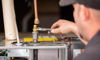 An air conditioning technician is working on a unit.
